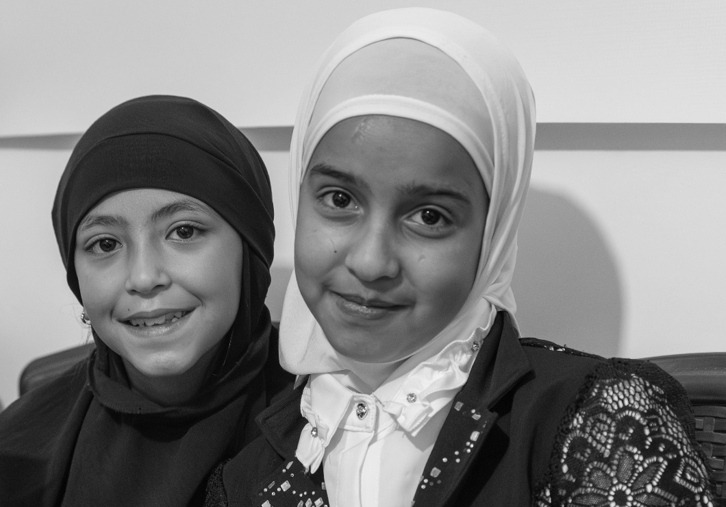 Two girls sitting close together, smiling